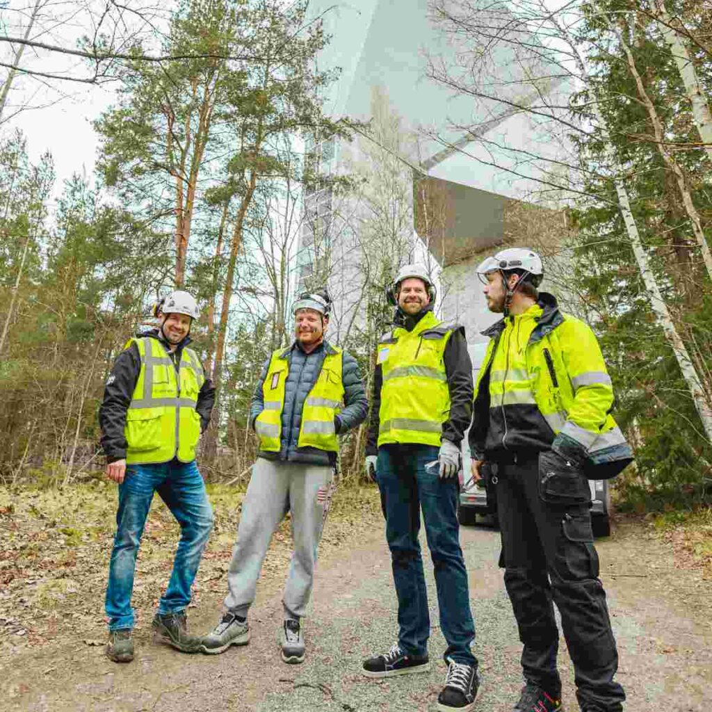 Concrete Urakointi, Kumppanit. Neljä Concreten työntekijää seisovat metsässä vesitorini juurella.